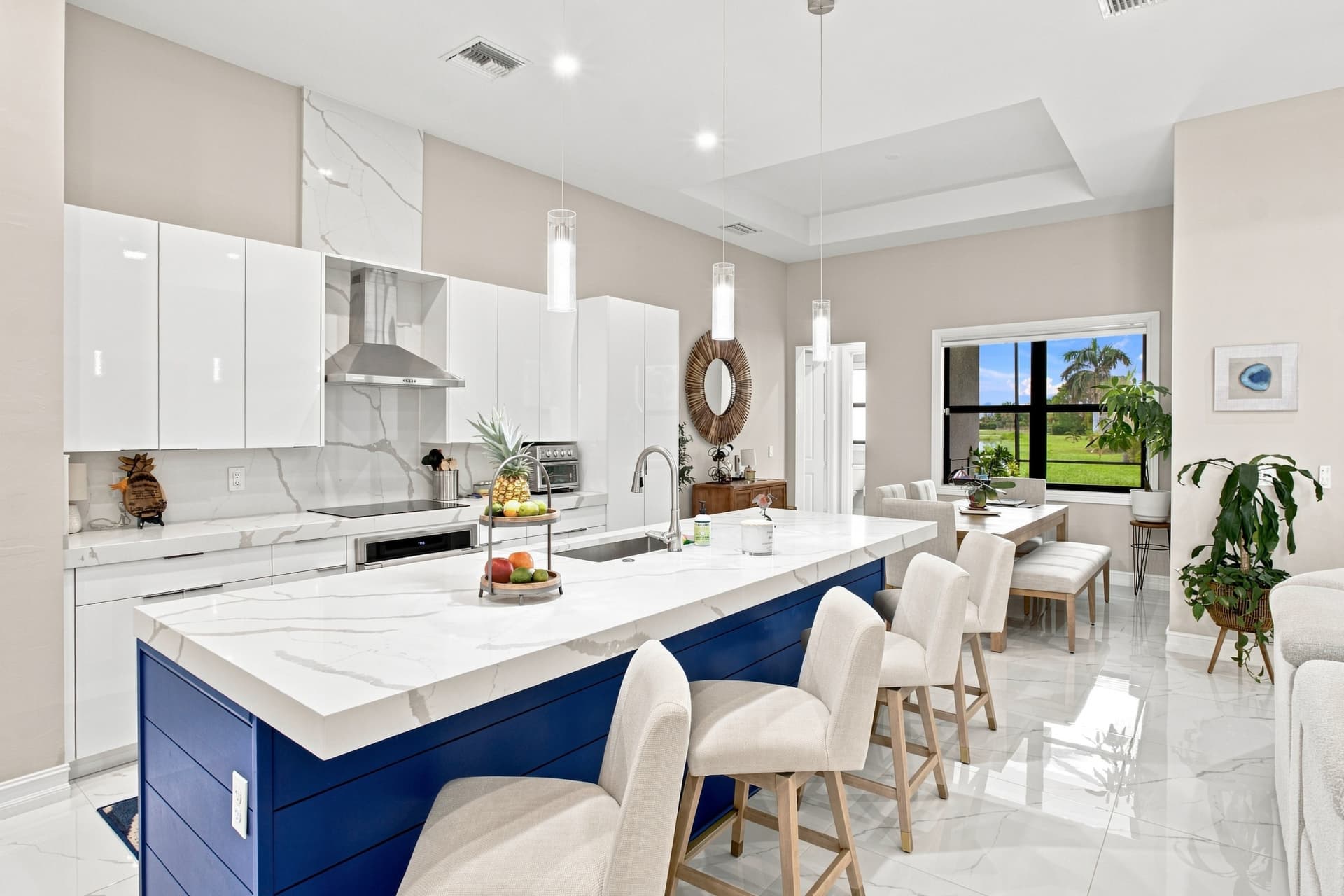 Modern white kitchen with a navy island and quartz counters in a Southwest Florida home